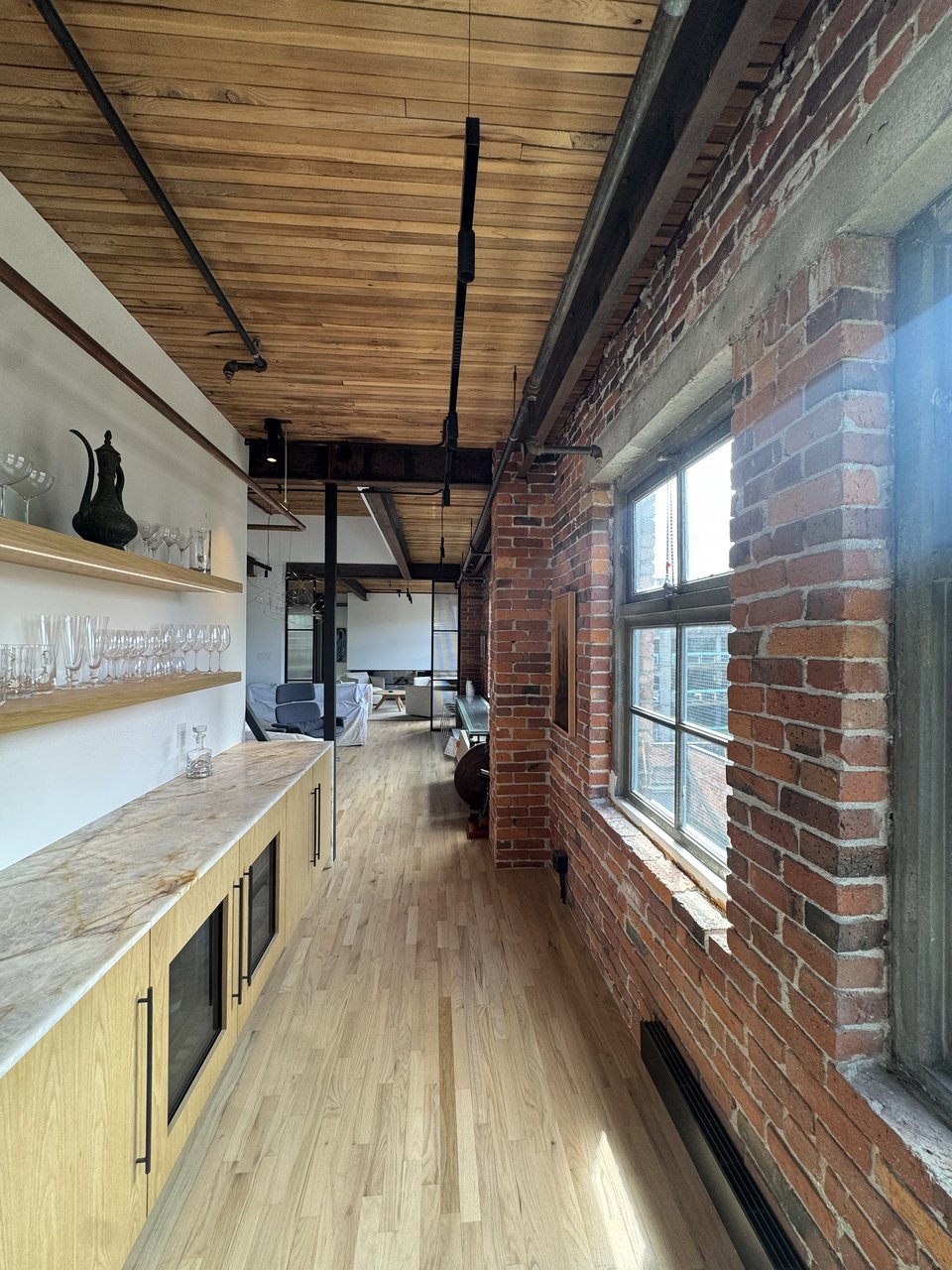 Exposed brick wall, floating shelves and black steel window in the Powell loft renovation, Vancouver BC
