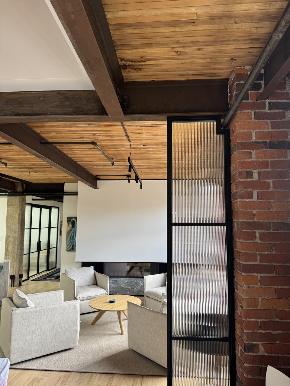 Exposed wood beam ceiling and black steel framed glass partition, Powell renovation