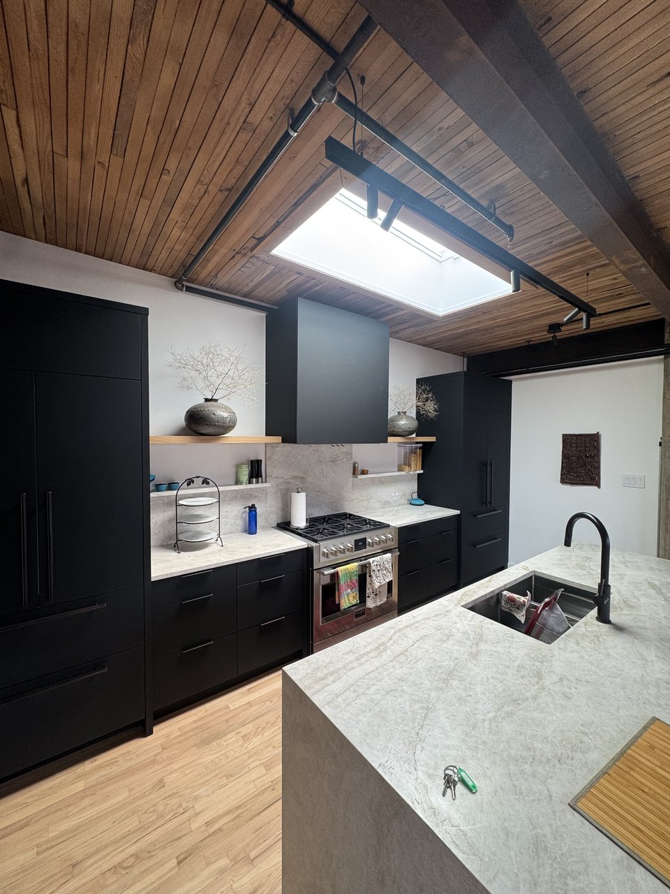 Dark cabinetry kitchen with stone counters and skylight, Powell renovation, Vancouver BC