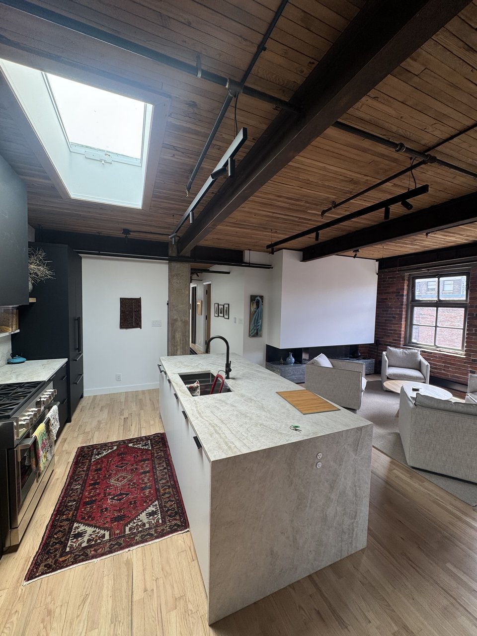 Open plan loft kitchen and living area with exposed wood beam ceiling, Powell renovation, Vancouver BC