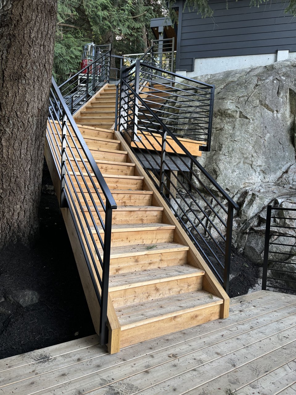 Custom deck stairs and steel railing on a sloped North Vancouver property